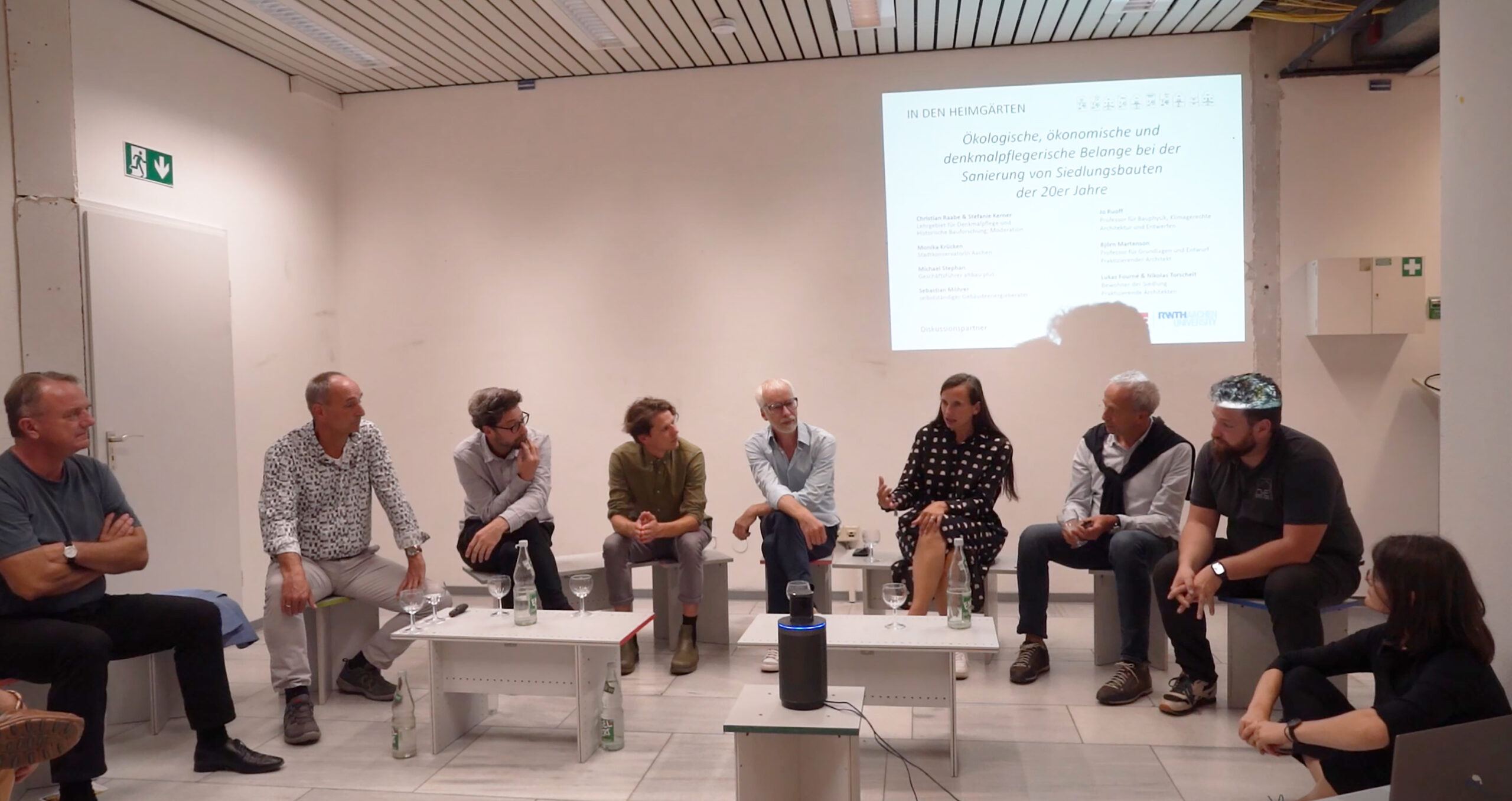 Neun Personen diskutieren im Rahmen einer Podiumsdiskussion