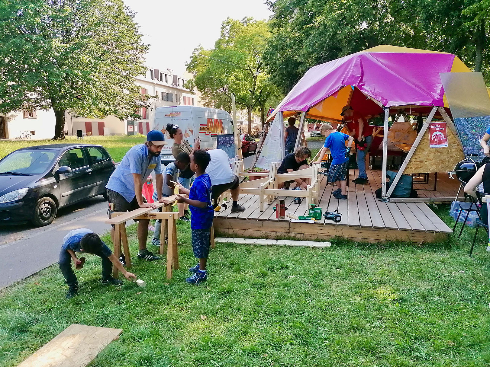 In und vor dem Habibi Dome bauen Kinder, Jugendliche und Erwachsene zusammen Möbel aus Holz.