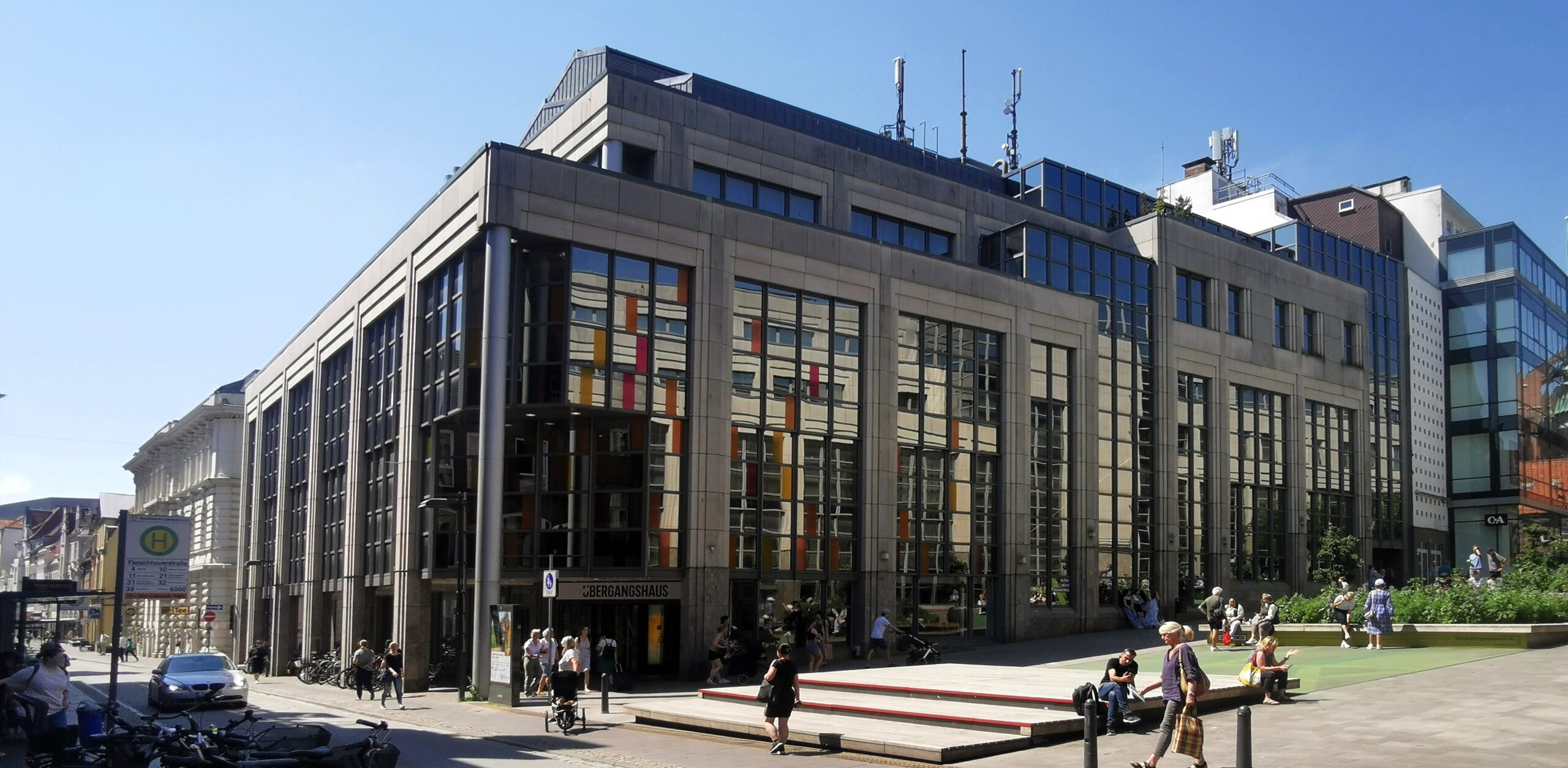 Eckansicht des leerstehenden Bestandsgebäudes. Das benachbarte Karstadt-Warenhaus spiegelt sich in den Fenstern.