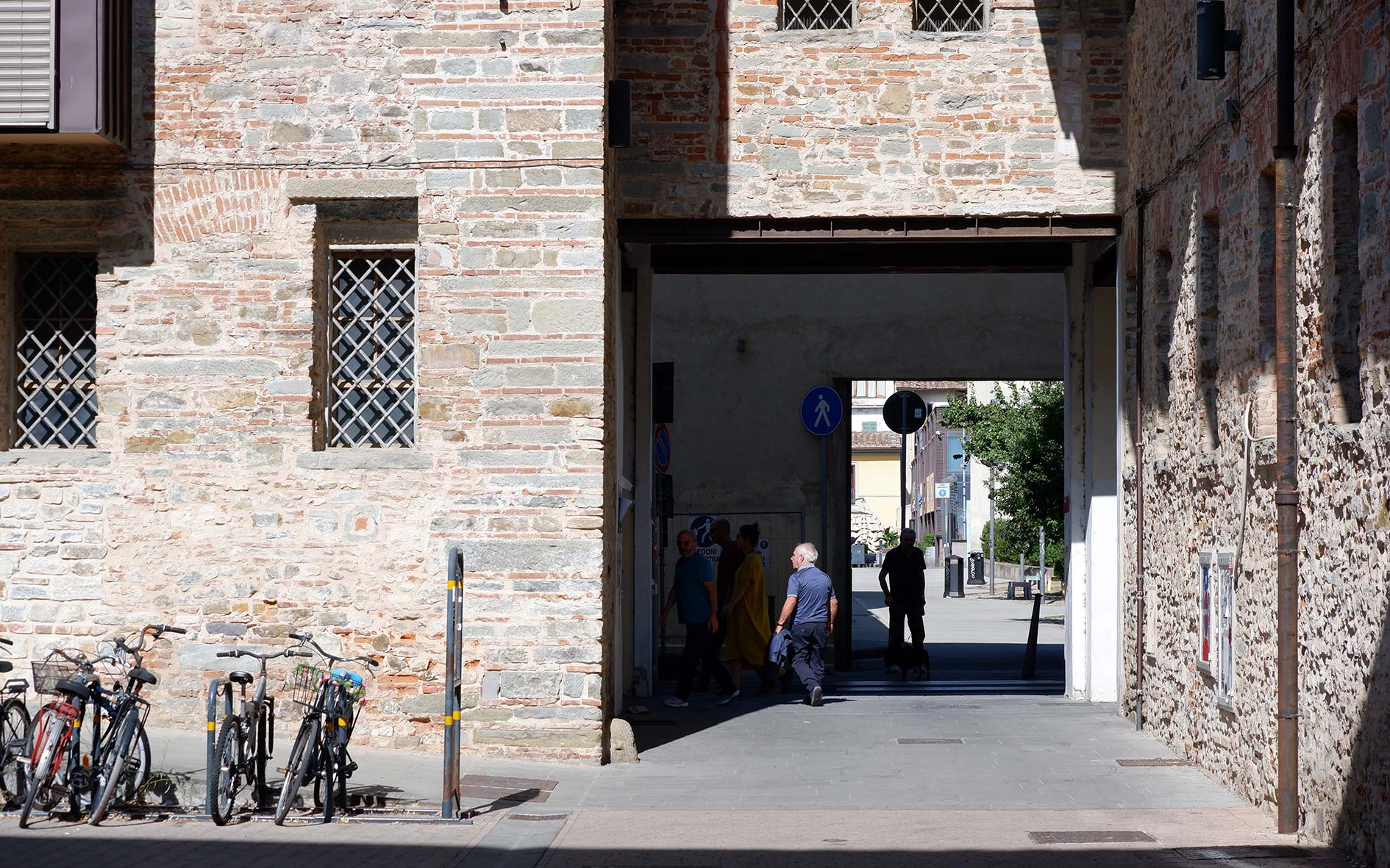 Original stone walls of Le Murate with a barred window and a small religious fresco set into the wall.